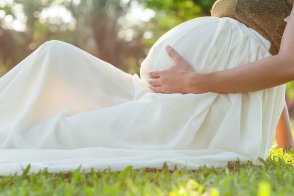 pregnant woman sitting in the park in the morning.