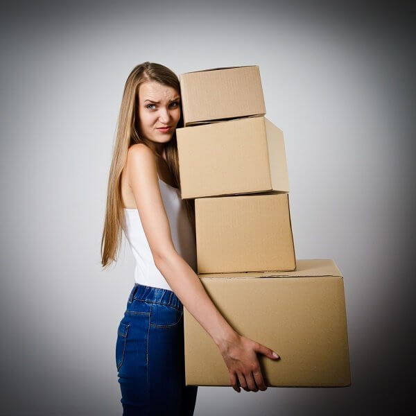 Woman holding a pile of packaged parcels. Woman doing something. Carton.