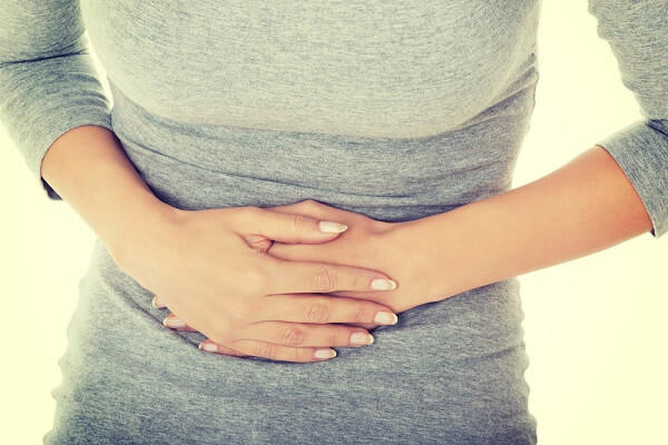 Young casual woman is having stomach ache.