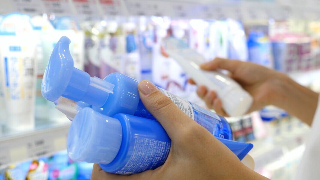 Close Up Of Female Hands With Cosmetic Goods In Skin Care Shop.