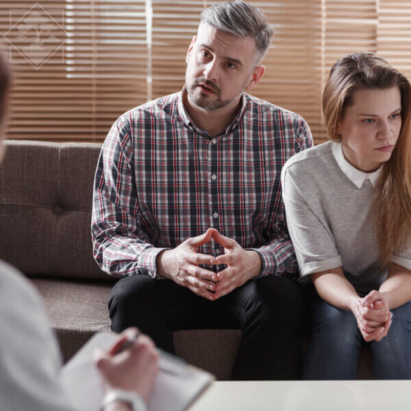 Couple discussing fertility treatment fears with doctor. 