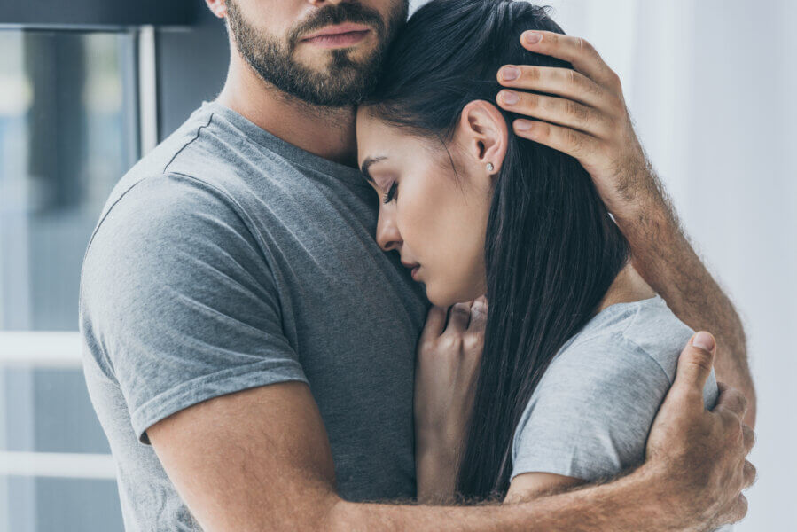 conceive fertility  cropped shot of bearded man hugging and supporting young sad woman